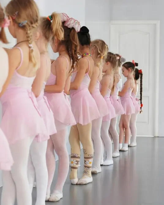 young group of ballet dancers stood in class