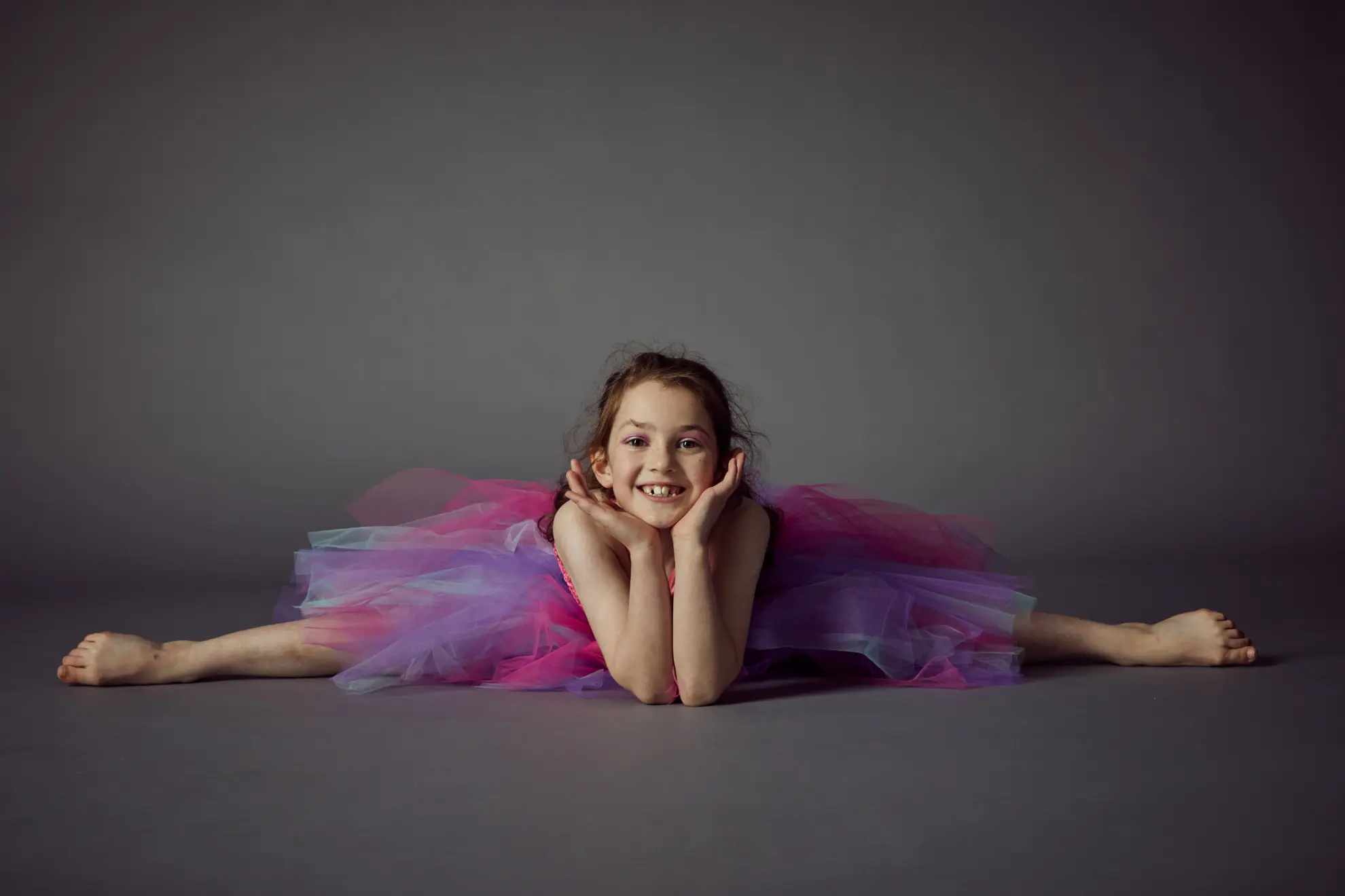 girl stretching her legs and doing the splits in a tutu