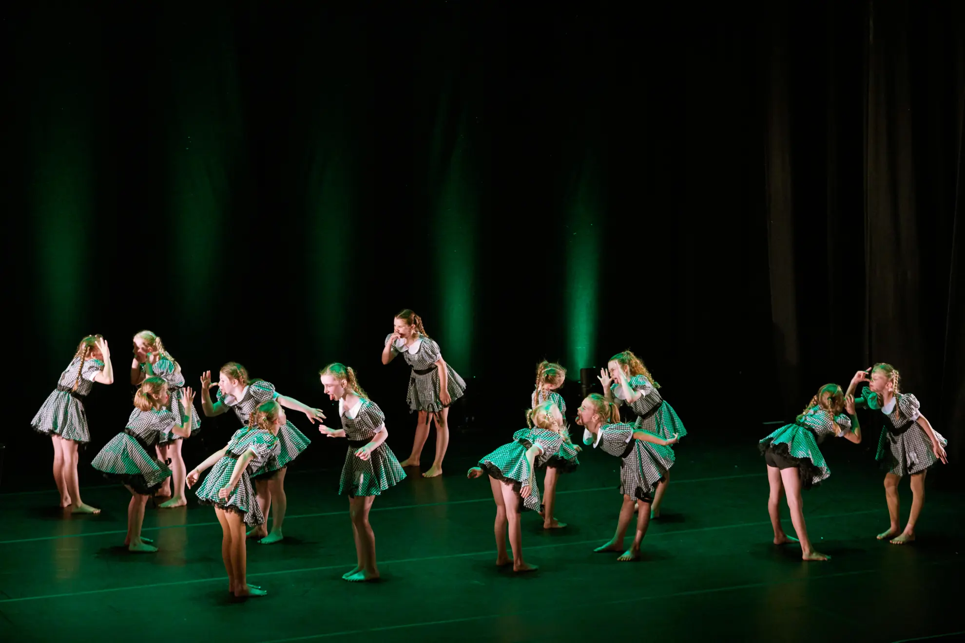 young girls on stage performing making faces at each other