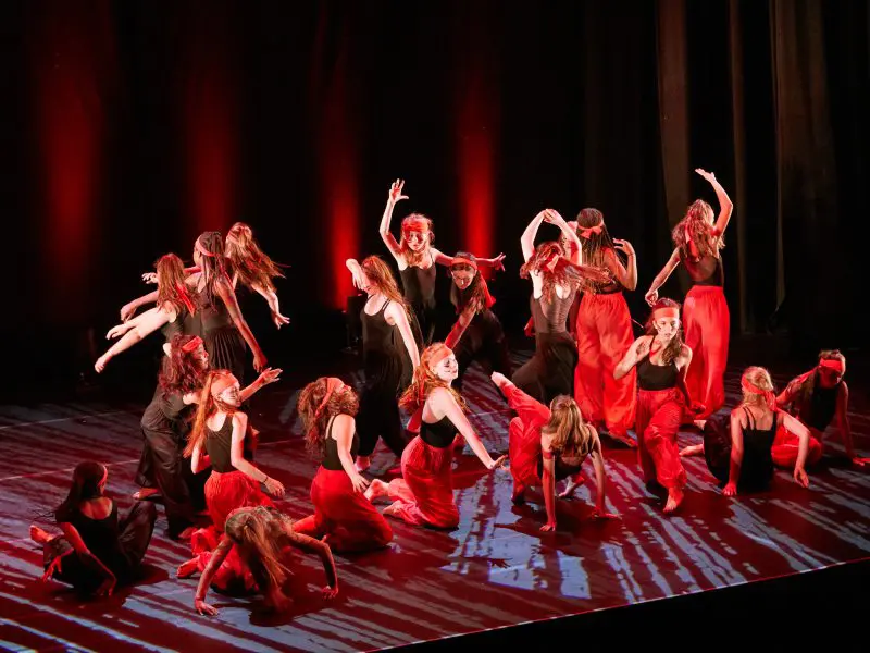 group of dancers performing a modern dance on stage