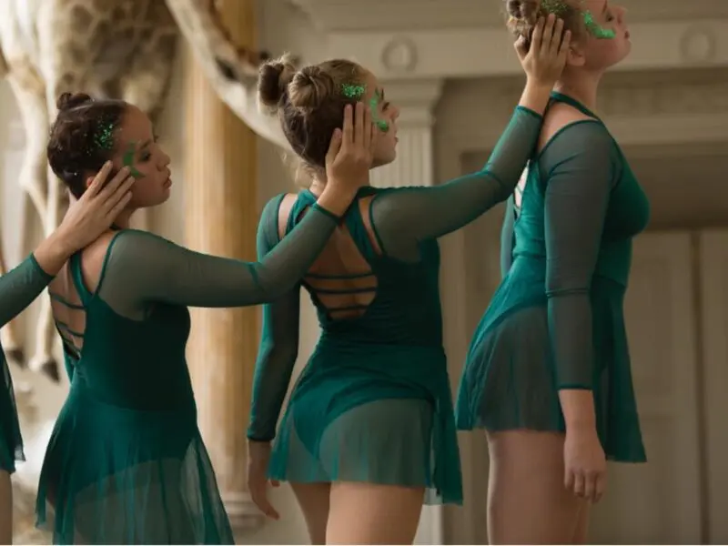 girls dancing together wearing green