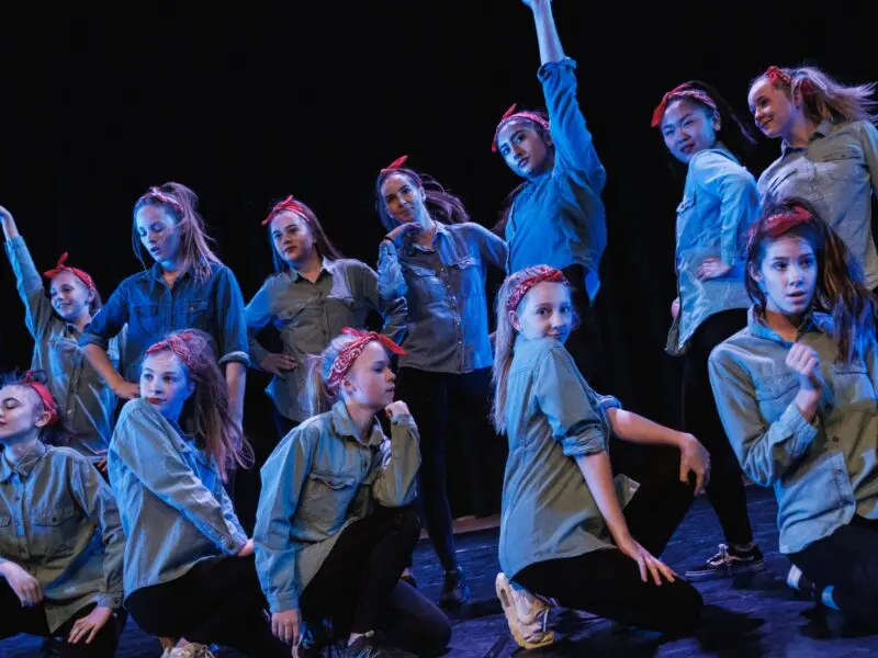 group of girls dancing in denim skirts and bandanas