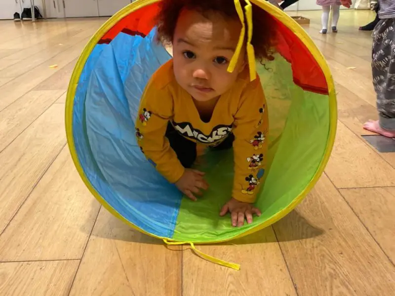 little baby crawling through a tunnel