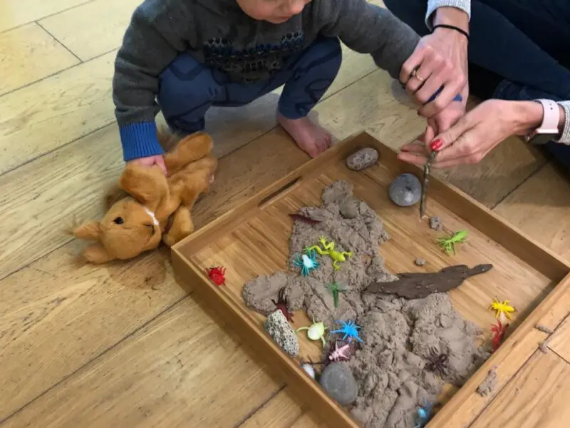 blonde baby playing in sand box