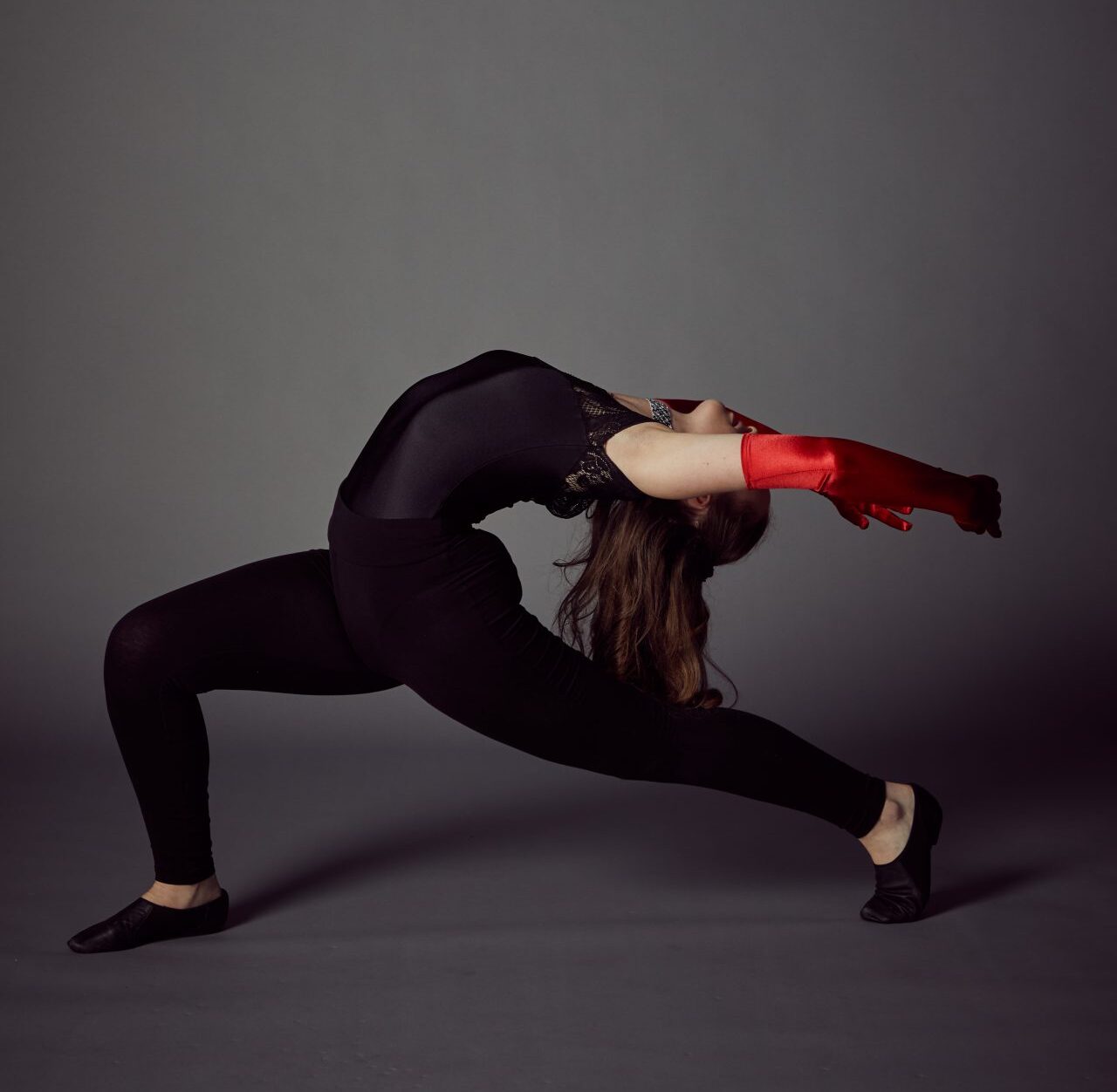 young girl in red gloves fully bending her back